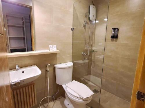a bathroom with a toilet and a shower and a sink at Cebu Uncle Toms Cabin Hotel powered by Cocotel in Cebu City
