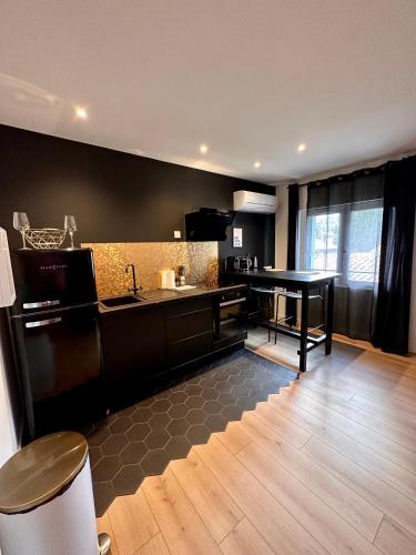 une cuisine avec un évier et une table à l'intérieur dans l'établissement La Belle Nuit suite Nuit Étoilée, à Saint-Gilles