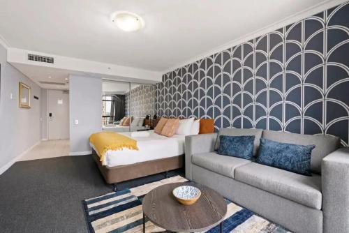 a living room with a couch and a bed at KozyGuru | Haymarket | Chic City Studio in Sydney