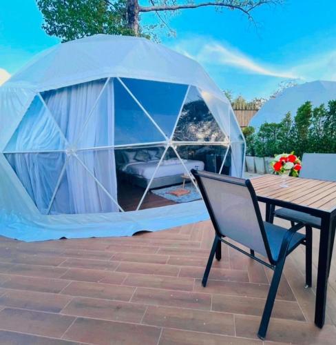 a tent on a patio with a table and a chair at Papa Q suite Hotel in Ban Non Muang