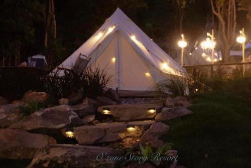 a white tent with lights in a yard at night at โอโซนสตอรี่ in Ban Fai Mon