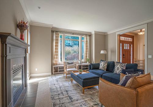 a living room with a blue couch and a fireplace at Kirkland's Expansive Custom-Built Family Haven Near Juanita in Kirkland