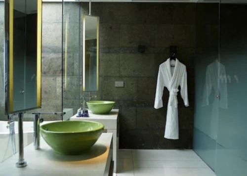a bathroom with a green bowl sink and a robe at W Bali - Seminyak in Seminyak