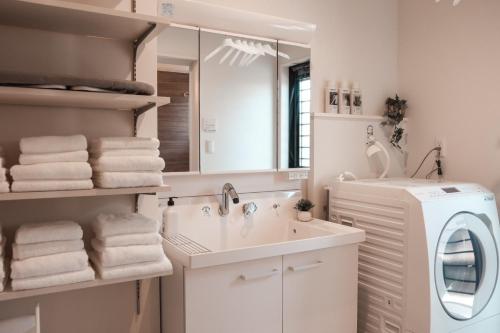 a bathroom with a sink and a washing machine at Mova Villa Haramizu in Kikuchi