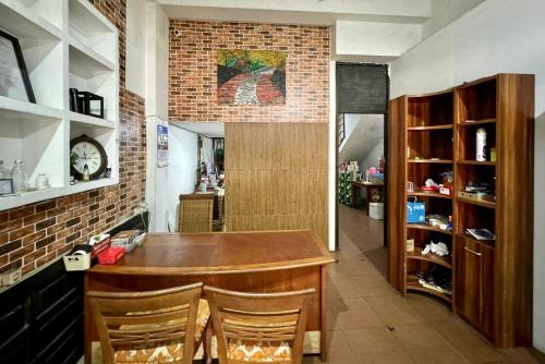 a kitchen with a bar with chairs and a brick wall at Backpacker Homestay Jatisampurna Redpartner in Bekasi
