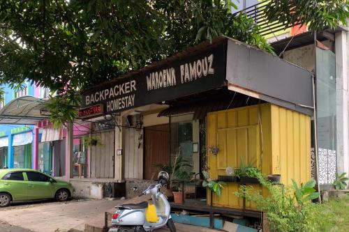 a scooter parked in front of a building at Backpacker Homestay Jatisampurna Redpartner in Bekasi