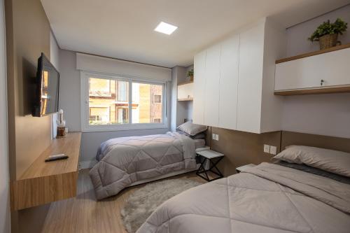 a bedroom with two beds and a window at Cantinho Encantado in Canela