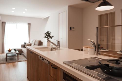 a kitchen with a sink and a stove top oven at Mova Villa Haramizu in Kikuchi