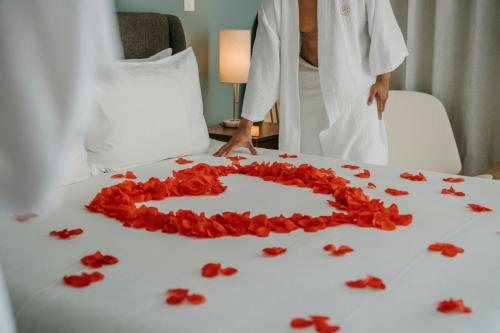 a woman standing next to a table with a heart of roses at VIDA Cayman Luxury Boutique Eco Hotel in West Bay