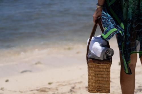 a person standing on the beach with a basket at VIDA Cayman Luxury Boutique Eco Hotel in West Bay