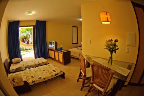 Solar Pipa Apartments في بيبا: غرفة معيشة مع طاولة طعام وغرفة نوم