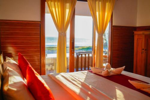 a bedroom with a bed with a view of the ocean at DESILA Beach House in Nusa Penida