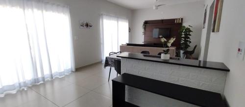 a living room with a kitchen with a fireplace at Chacara LP Boituva in Boituva