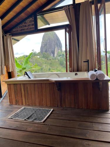 a bath tub with a view of a tree at Ecoedén glamping in Guatapé