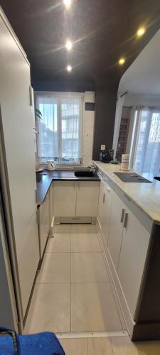 une cuisine avec des placards blancs et une grande fenêtre dans l'établissement Vue tour eiffel, à Saint-Cloud