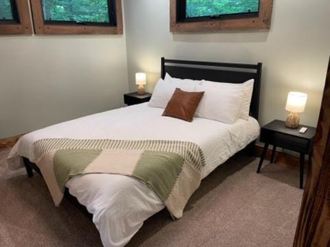a bedroom with a large bed with two night stands at Pine Creek Cabins & Camping Resort in South Bloomingville