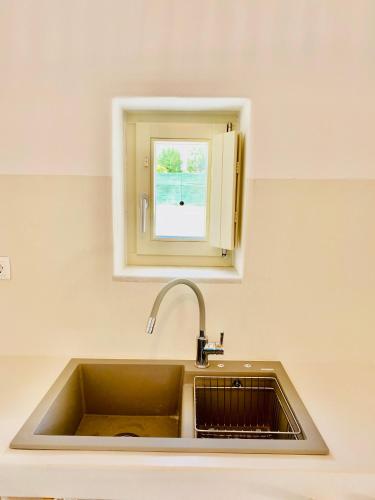 a kitchen sink with a window above it at Yannis Boutique Cycladic House in Kampos Paros