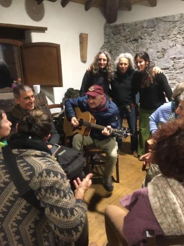 a group of people standing around a man playing a guitar at Agriturismo La Caraffara sull' Etna in Puntalazzo