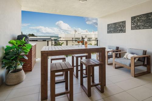 a dining room with a table and chairs on a balcony at Bright Stylish Kings Beach Apartment in Caloundra
