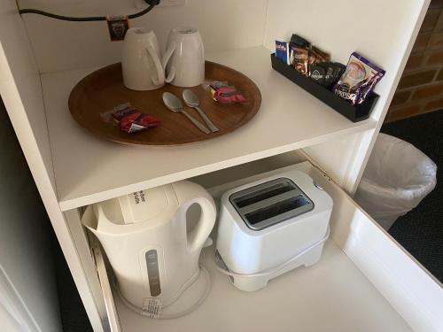 a kitchen counter with a tea pot and a plate at Buckaroo Motor Inn in Warwick