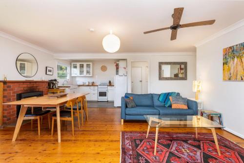 a living room with a blue couch and a table at 58 Wallaga Lake Road in Bermagui
