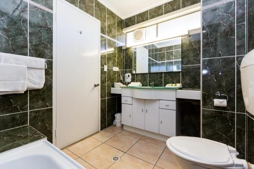 a bathroom with a toilet and a sink at Elkira Court Motel in Alice Springs