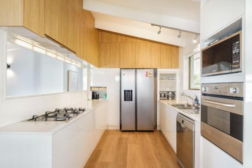 a kitchen with white counters and a stainless steel refrigerator at Montville Retreat With Hinterland & Coastal Views in Montville