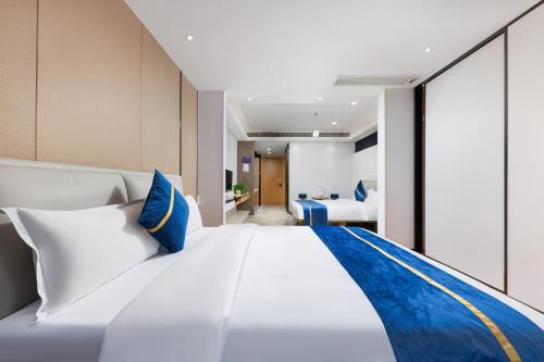 a bedroom with a large white bed with blue accents at Cloudy international apartment Beijing Rd A-mall in Guangzhou