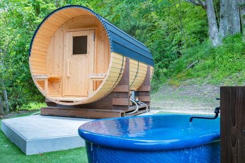 a small wooden sauna with a tub in front of it at 古民家の宿 和ごろも-Wagoromo- in Ōtaki