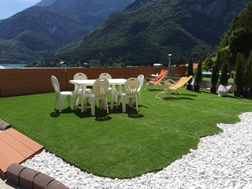 a table and chairs on a lawn with mountains in the background at Residenza Alba - Molveno in Molveno