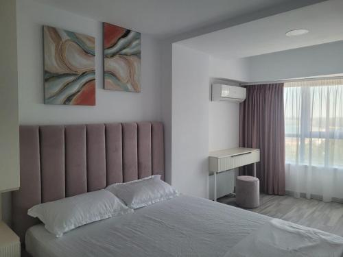 a bedroom with a bed with two paintings on the wall at Aphrodite Olimp - Luxury apartment with sea view & pool in Olimp