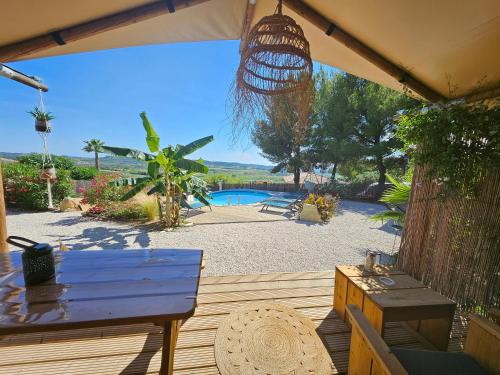 une terrasse avec une table bleue et une piscine dans l'établissement DOMAINE DU CHENE, à Campagnan