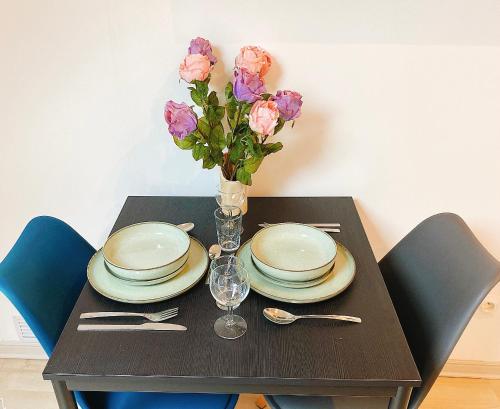 une table avec des assiettes et un vase de fleurs dans l'établissement Pacello studio, à Amboise
