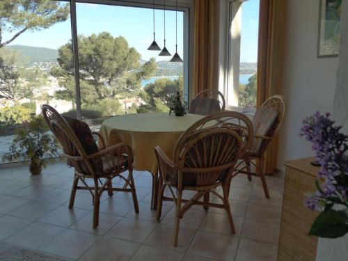 une salle à manger avec une table et des chaises et une grande fenêtre dans l'établissement Les Heures Bleues Paradis, à Cavalaire-sur-Mer