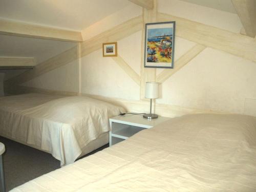 une chambre avec deux lits et une table avec une lampe dans l'établissement Cosy holiday home near town centre, à Cavalaire-sur-Mer