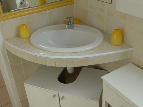 La salle de bains est pourvue de 2 lavabos jaunes. dans l'établissement Cosy holiday home near town centre, à Cavalaire-sur-Mer