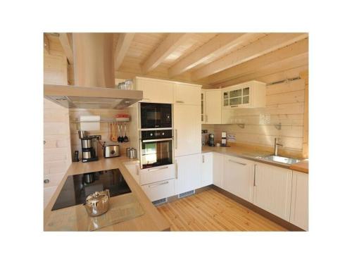 Il comprend une grande cuisine avec des placards blancs et du parquet. dans l'établissement Le Sine Nomine Comfortable holiday residence, à Bœrsch