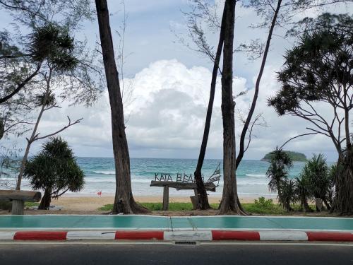 a view of a beach with a bench and trees at 7 Floor - Mountain view Studio room at OZC near Kata beach in Kata Beach