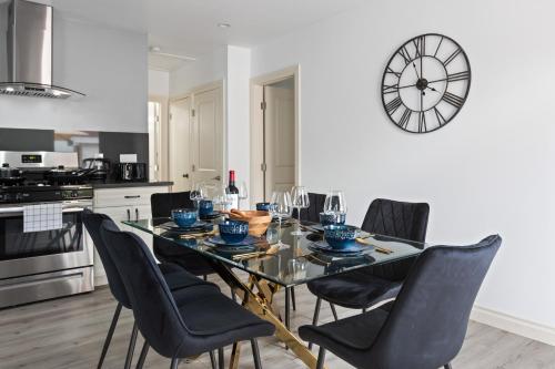 a dining room table with chairs and a clock on the wall at Luxury Oasis in Culver City! Free parking and Jacuzzi in Los Angeles