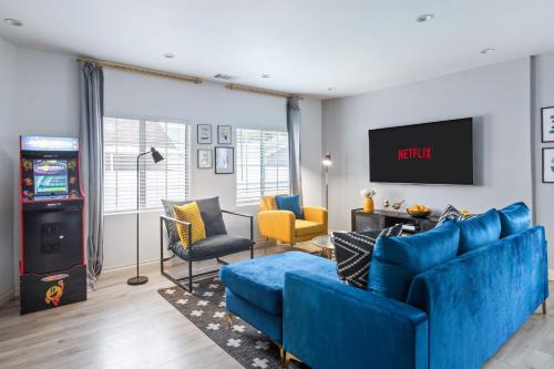 a living room with blue couches and a video game at Luxury Oasis in Culver City! Free parking and Jacuzzi in Los Angeles