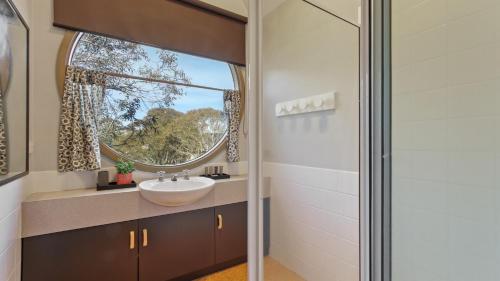 a bathroom with a sink and a window at Aaragon in Dinner Plain
