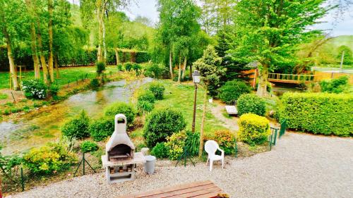 a garden with a grill in the middle of a park at Cabanes flottantes et gîtes au fil de l'eau in Colleville
