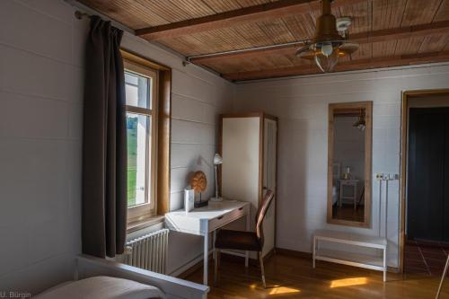 a room with a desk and a window and a table at BnB SchlafSchloss in Sumiswald