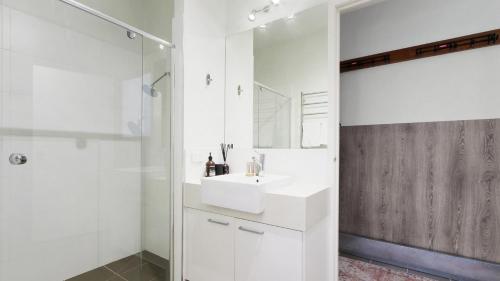 a white bathroom with a sink and a shower at Apres in Dinner Plain