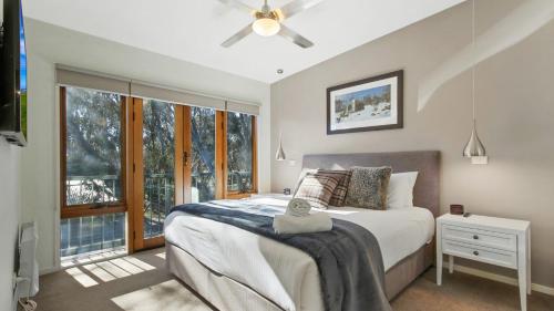 a bedroom with a bed and a large window at Apres in Dinner Plain
