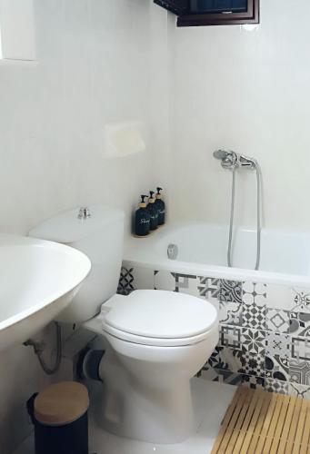 a white bathroom with a toilet and a sink at Holiday home with view in Pefkochori