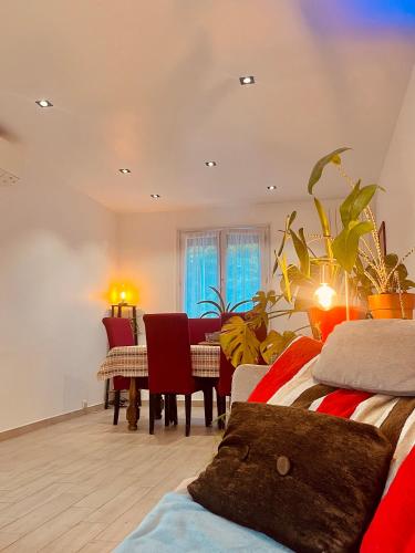 une pièce avec une table et une salle à manger dans l'établissement Appart Lumineux avec Jardin et Jacuzzi - Chambre Parentale - Full AC - Proche - CDG - Stade de France - Parc des Expositions, au Blanc-Mesnil