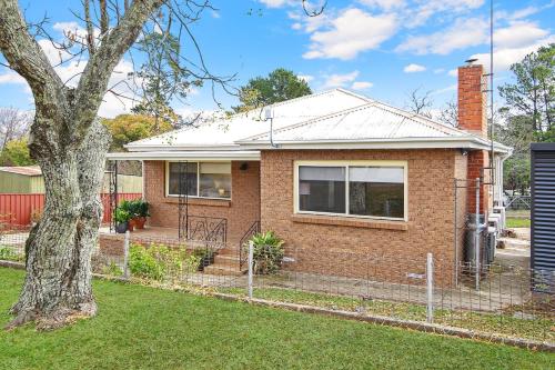 a brick house with a tree in the yard at Lake Reflections in Beechworth