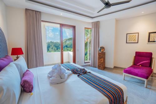 1 dormitorio con cama blanca y silla morada en The Bodhi Leaf Wellness Resort, en Saba