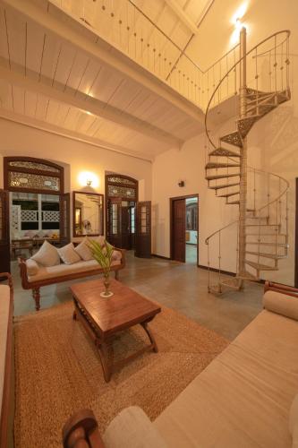 a living room with a spiral staircase and a table at Idda Boutique Villa - Four Bedroom Luxury Villa with Private Pool Near the Beach in Ahangama